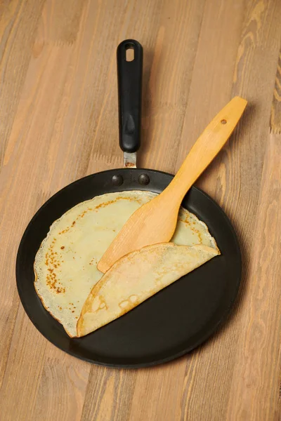 クレープ クローズ アップ フライパン ウッドの背景に薄いパンケーキ — ストック写真