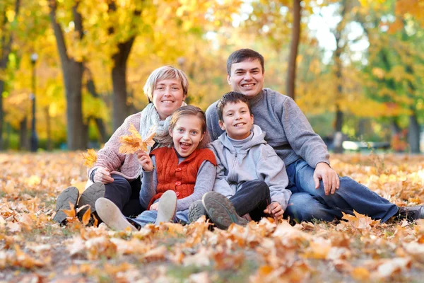 愉快的家庭在秋天城市公园在落叶说谎 孩子们和家长摆姿势 玩耍和娱乐 明亮的黄色树 — 图库照片
