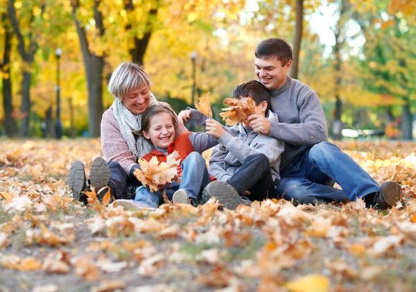 Счастливая Семья Сидит Осеннем Городском Парке Опавших Листьях Дети Родители — стоковое фото