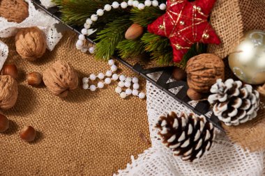 Noel dekorasyon arka plan, çam ağacı, tekstil, boncuk, hediyeler, eski kağıt, fındık ve çul diğer şeyler. Metin, yeni yıl tema için boş yer.