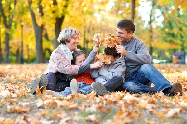 Lycklig Familj Sitter Höst Stadsparken Nedfallna Löv Barn Och Föräldrar — Stockfoto