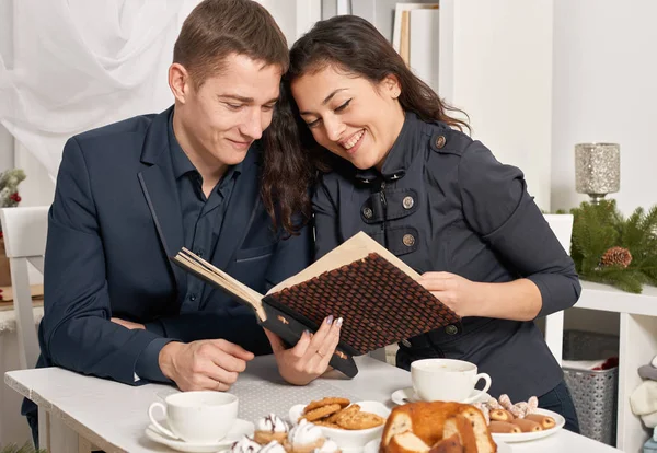 浪漫夫妇喝茶与饼干 说话和看相册 — 图库照片