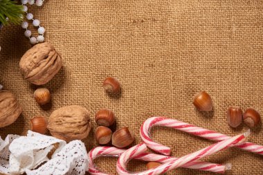 Noel dekorasyon arka plan, çam ağacı, tekstil, hediyeler, eski kağıt, fındık ve çul diğer şeyler. Metin, yeni yıl tema için boş yer.