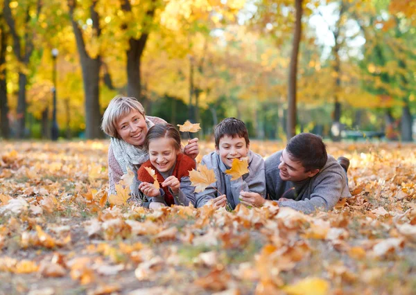 Glückliche Familie Liegt Herbstlichen Stadtpark Auf Abgefallenem Laub Kinder Und — Stockfoto