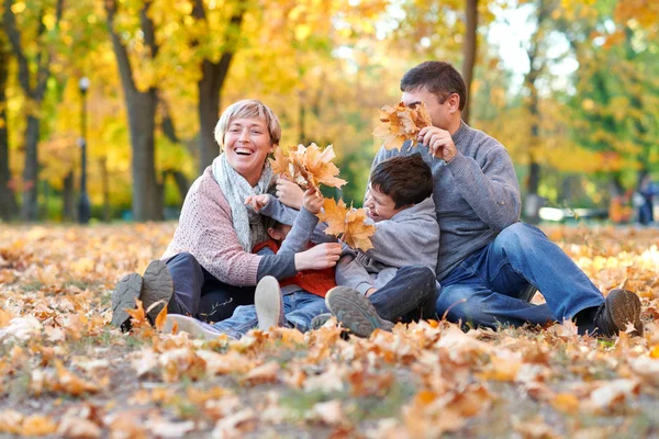 Szczęśliwe Rodziny Siedzieć Jesienny Park Miejski Opadłych Liści Dzieci Rodzice — Zdjęcie stockowe