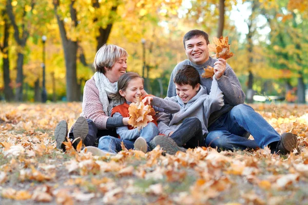 Glückliche Familie Sitzt Herbstlichen Stadtpark Auf Abgefallenen Blättern Kinder Und — Stockfoto