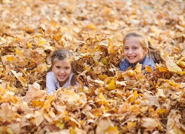 Çocuk yalan ve sonbahar Şehir Parkı içinde düşen yapraklar üzerinde oyun.