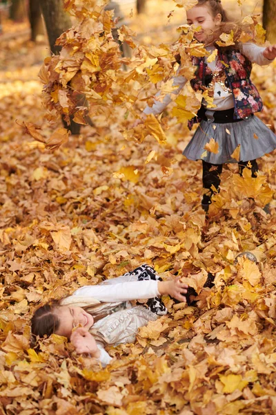 Bambino Ragazza Sdraiato Giocare Foglie Cadute Nel Parco Della Città — Foto Stock