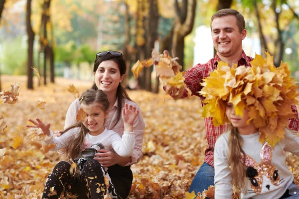 幸福的家庭是在秋天的城市公园 孩子和父母 他们摆姿势 玩耍和乐趣 明亮的黄色树 — 图库照片