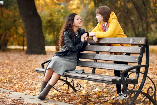 Twee Meisjes Zijn Herfst Stadspark Zitten Bank Praten — Stockfoto