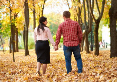 İki sonbahar Şehir Parkı içinde yürüyor. Parlak sarı ağaçlar.