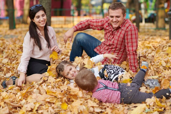 幸福的家庭是在秋天的城市公园 孩子和父母 他们摆姿势 玩耍和乐趣 明亮的黄色树 — 图库照片