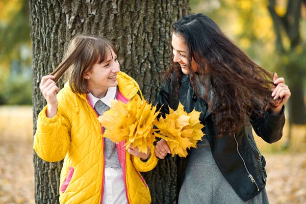 Dos Chicas Están Parque Otoño Paran Cerca Del Árbol Muestran — Foto de Stock