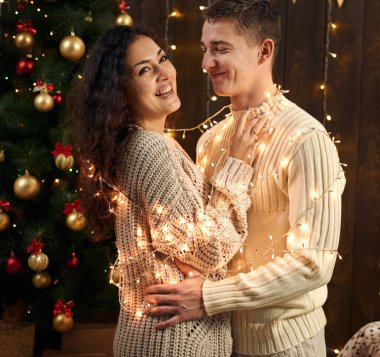 Genç bir çift olan Noel dekorasyonu ve ışıklar, köknar ağacı Yılbaşı tatil kavramı koyu ahşap arka plan üzerinde