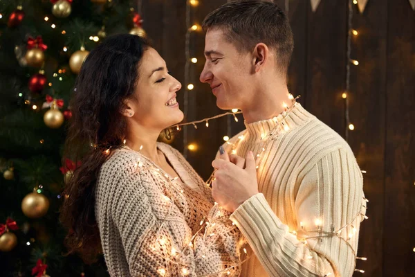 Giovane Coppia Decorazione Natale Luci Abete Sfondo Legno Scuro Concetto — Foto Stock