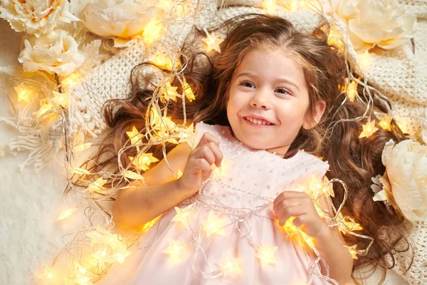 Flicka Barn Ljuger Med Julbelysning Och Blommor Face Närbild — Stockfoto