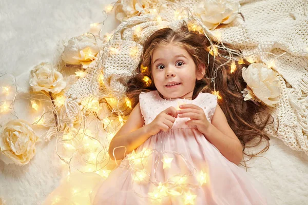 Flicka Barn Ljuger Med Julbelysning Och Blommor Face Närbild — Stockfoto