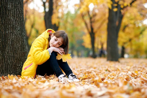 Smutna Dziewczyna Siedzi Pobliżu Drzewa Parku Jesień Jasne Żółte Liście — Zdjęcie stockowe