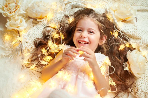 Flicka Barn Ljuger Med Julbelysning Och Blommor Face Närbild — Stockfoto