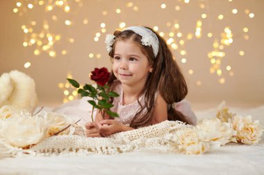 gül çiçek kız çocuk Noel ışıkları, sarı arka plan, pembe elbisenin içinde poz