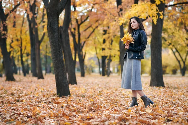 漂亮的女人在秋天的公园里摆姿势 拿着一堆枫叶 她闭上眼睛做梦 秋天的美丽的风景 — 图库照片