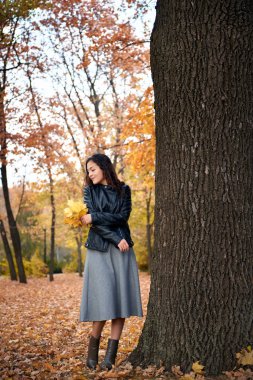 Maple'nın yaprakları büyük ağaç sonbahar Parkı ile poz güzel kadın. Sonbahar sezonu, güzel manzara.