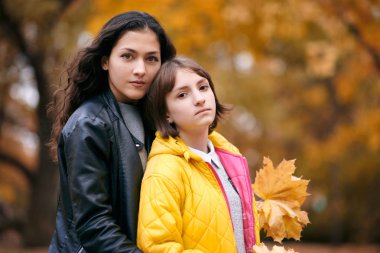 Güzel kadın ve Genç kız grup Sonbahar Park akçaağaç'ın yaprakların ile poz. Sonbahar sezonu, güzel manzara.