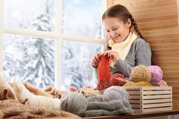 女孩正坐在窗台上 上面有羊毛纱线和针织 窗外美丽的景色 冬日和雪的阳光明媚的日子 — 图库照片