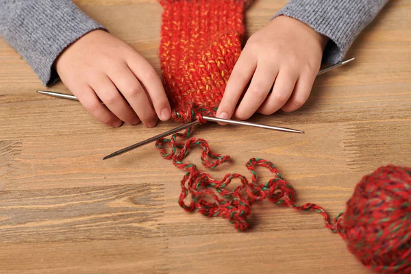 Ein Mädchen Lernt Gerade Einen Schal Stricken Auf Dem Holztisch — Stockfoto