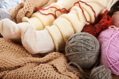 Bir pencere pervazına yün iplikler ile sıcak çorap alt bacaklar yanıyor.