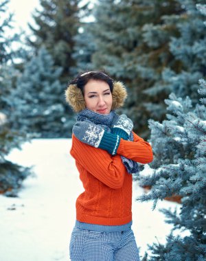 Kadın kış orman, güzel manzara karlı köknar ağaçları ile poz. Kırmızı kazak ve etkilidirler giymiş