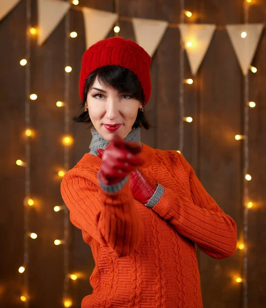 여자는 어두운 크리스마스 플래그 개념에 장갑과 빨간색 모자와 스웨터를 — 스톡 사진