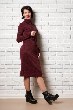 Güzel kadın beyaz tuğla duvar arka plan poz