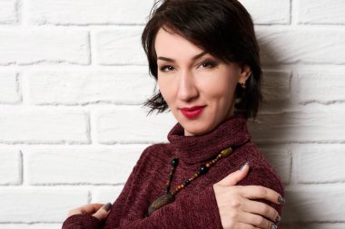 Güzel kadın beyaz tuğla duvar arka plan poz