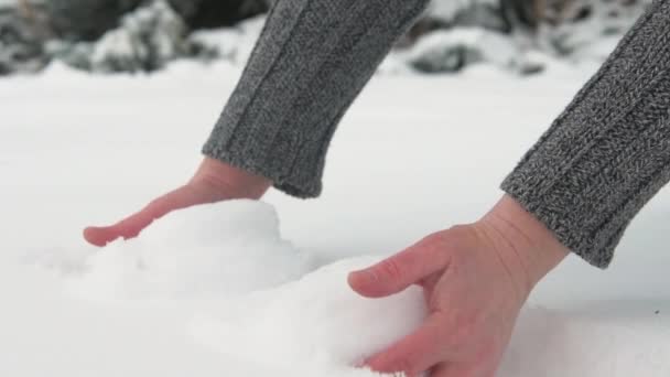 女人得到一把雪 并使一个雪球 雄弹关闭 美丽的风景与雪的冷杉树 — 图库视频影像