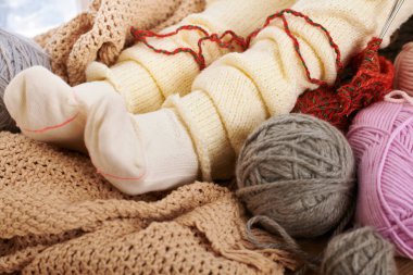 Bir pencere pervazına yün iplikler ile sıcak çorap alt bacaklar yanıyor.