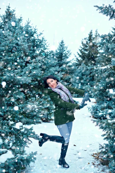 美丽的女人是在冬天的森林里 绿色的冷杉树与雪 — 图库照片