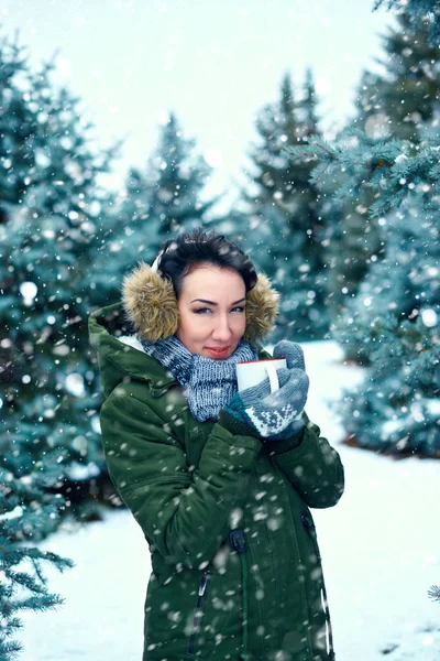 美丽的女人喝茶在冬天的森林 绿色的冷杉树与雪 — 图库照片