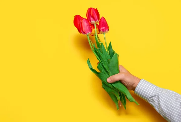 愛する男を空白スペースで手赤い花束、黄色背景に保持し、休日の概念 — ストック写真