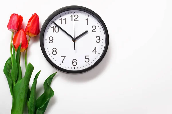 Ramo de flores rojas y reloj sobre fondo blanco - tiempo, amor y concepto de vacaciones — Foto de Stock