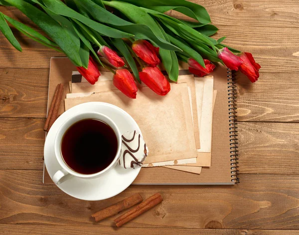 Bouquet tulipano è su sfondo legno, tazza di caffè, vecchi fogli di carta bianca per il testo, stile retrò — Foto Stock