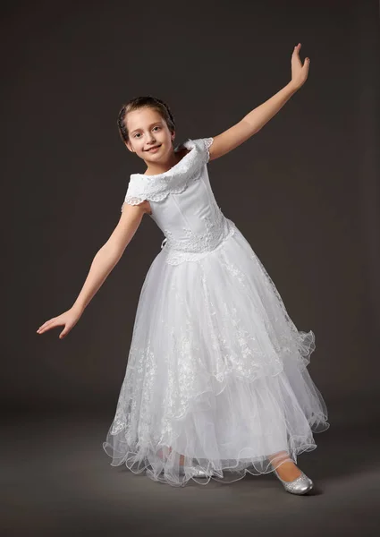 Niña está posando en un vestido de bola blanco, fondo oscuro — Foto de Stock