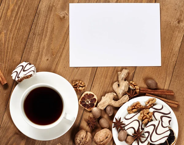 Tazza bianca di caffè e biscotti su sfondo di legno, spezie e decorazioni, foglio di carta bianco per testo, vista dall'alto — Foto Stock