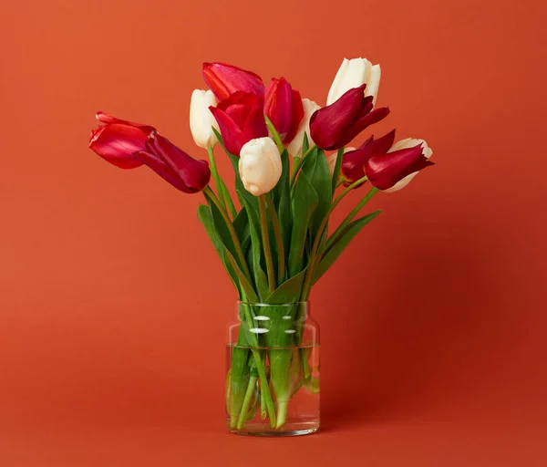 Tulp bloemen zijn in een vaas op bruine achtergrond — Stockfoto