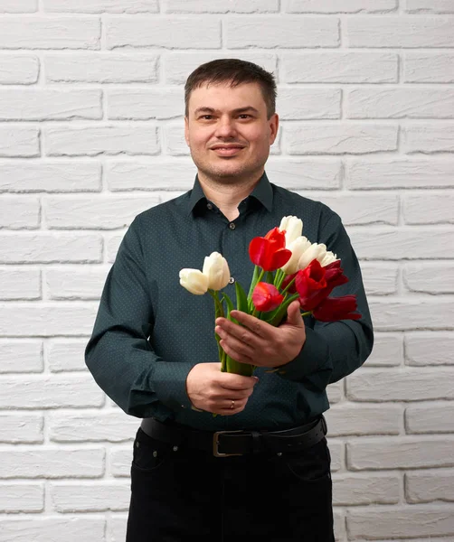 Man håller röda blommor bukett — Stockfoto