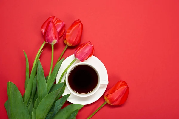 赤い花の束は赤背景コーヒーのカップと愛と休日の概念 — ストック写真
