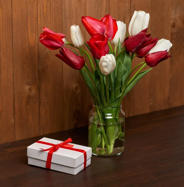 Tulip flowers are in a vase, wooden background — Stock Photo, Image