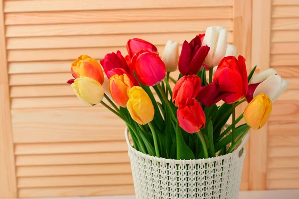 Tulipa flores estão em uma cesta sobre a mesa, fundo de madeira — Fotografia de Stock