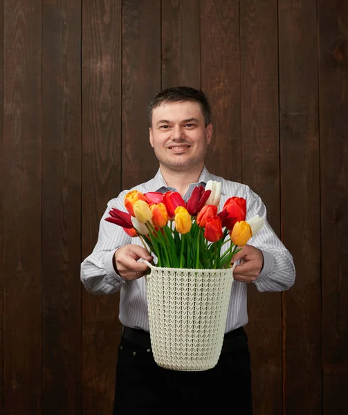 Mann hält einen Korb mit Blumen — Stockfoto