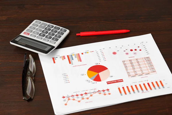 Relatórios vermelhos, gráficos e calculadora para calcular finanças em escritório de mesa. Contabilidade financeira das empresas . — Fotografia de Stock